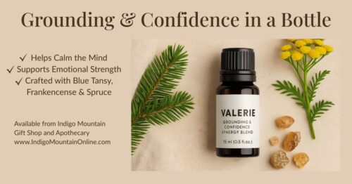 Valerie Grounding & Confidence Synergy Blend essential oil bottle on a beige background with spruce, blue tansy flowers, frankincense resin, and linen cloth. Text overlay highlights benefits: Helps calm the mind, supports emotional strength, crafted with Blue Tansy, Frankincense, and Spruce.